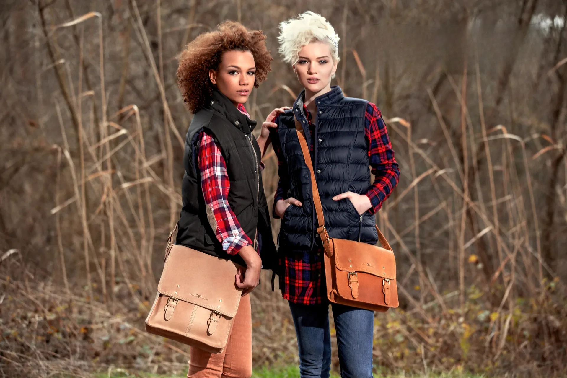 Zwei Frauen in Karohemden und Westen mit Ledertaschen in herbstlicher Natur